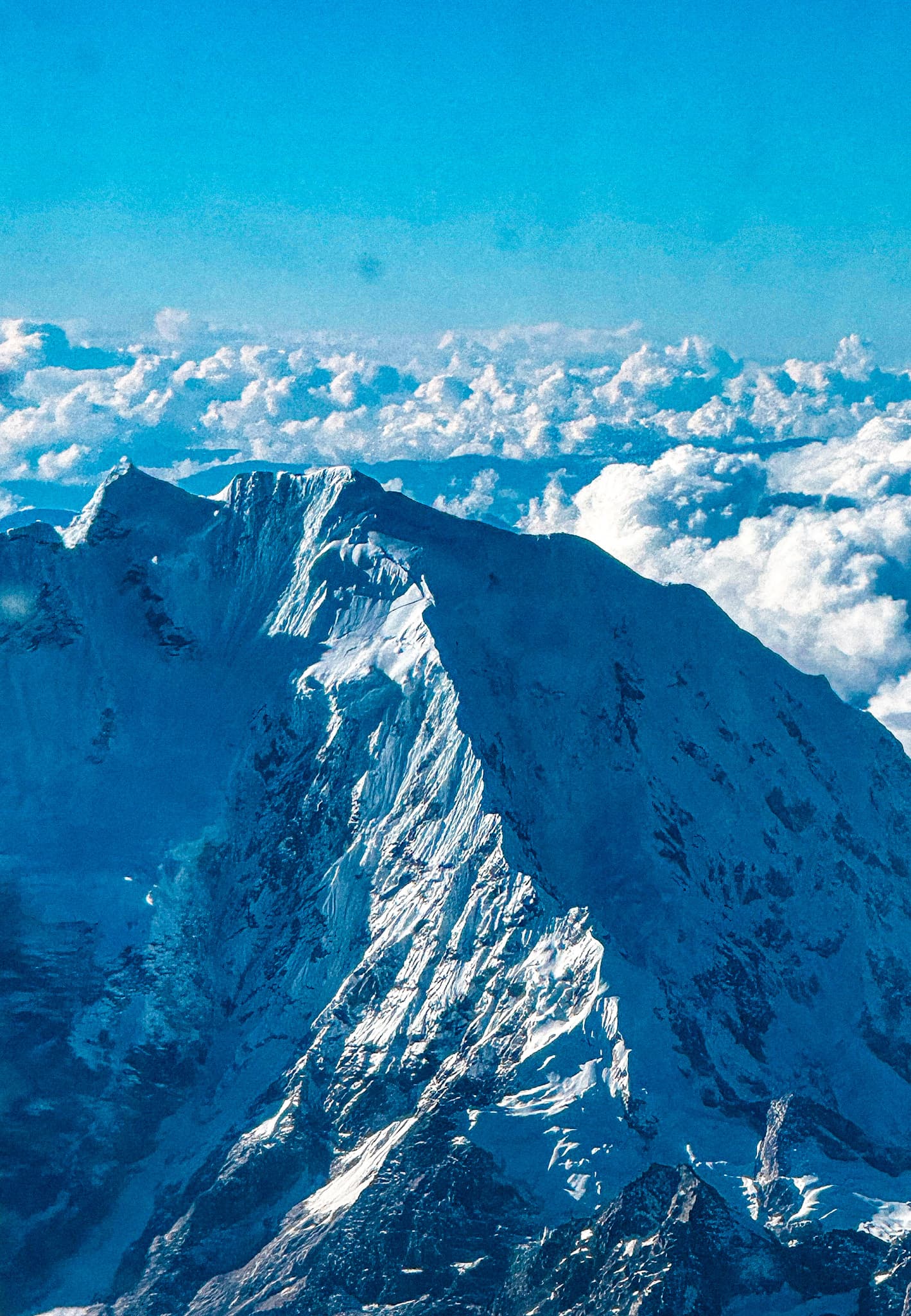 Snow-covered Andean peaks above the clouds